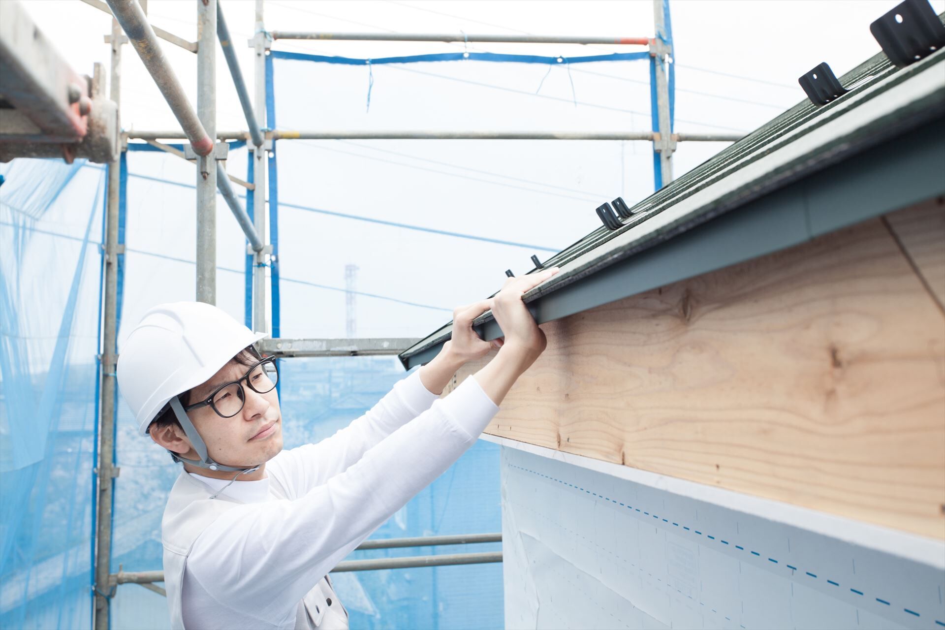 屋根の作業をする建築現場の男性スタッフ